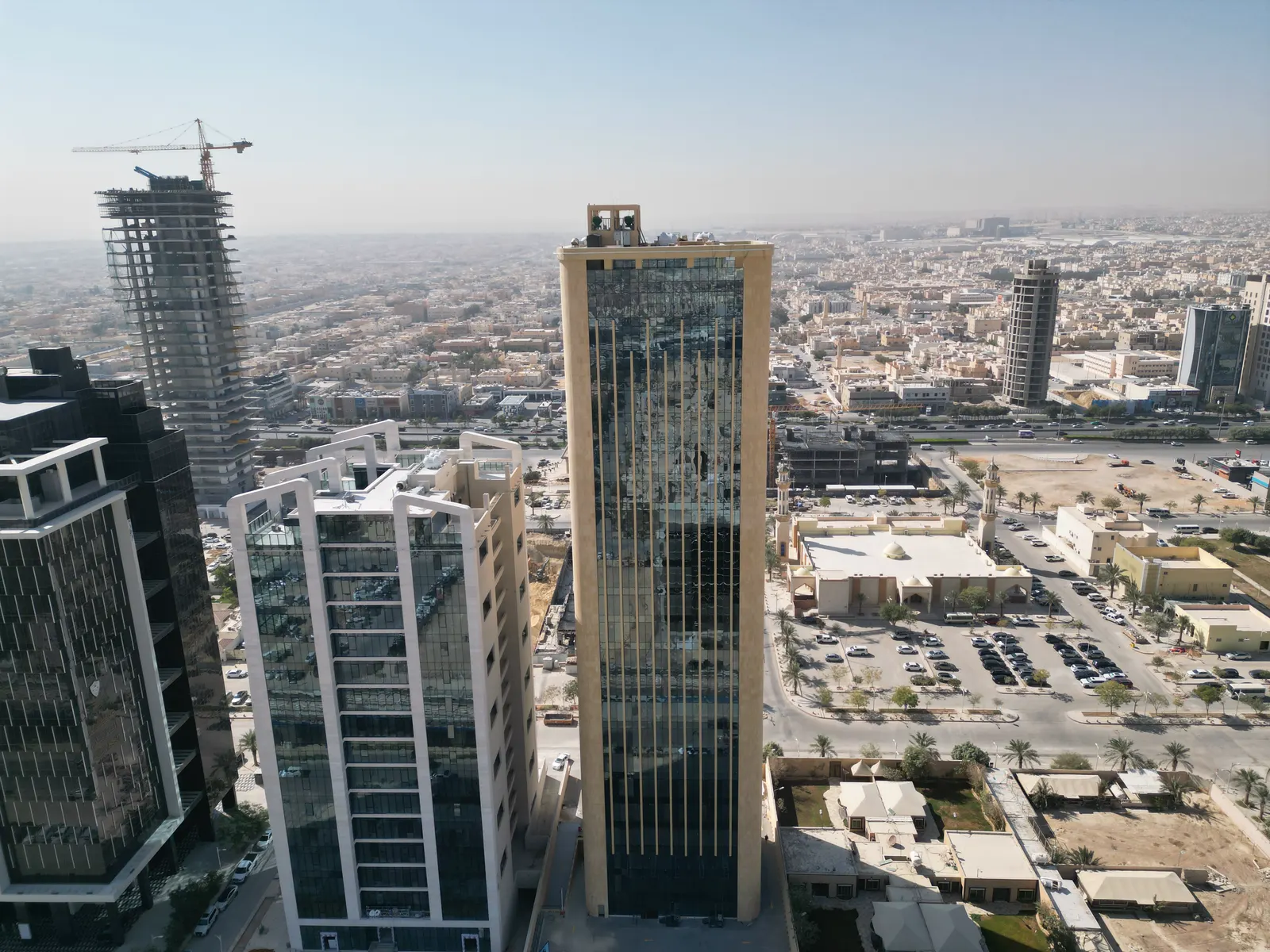 منظر جوي للبرج بجوار مبنيين مكتبيين، والرياض ممتدة حتى الأفق.