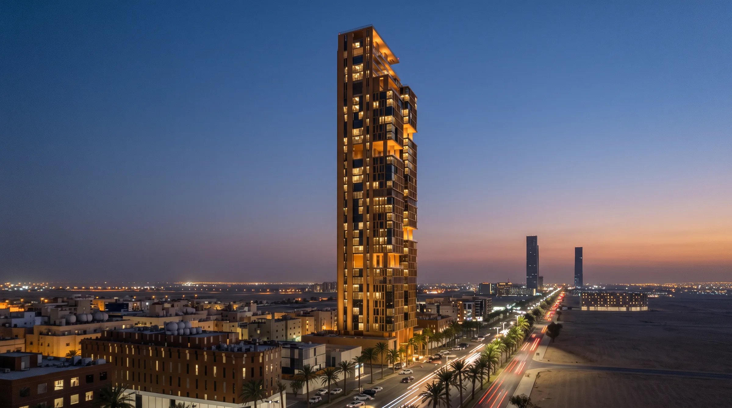 البرج عند الغسق بنوافذ مضاءة بضوء دافئ، والنخيل وحركة السيارات على طريق الملك فهد أسفله، تصور معماري.