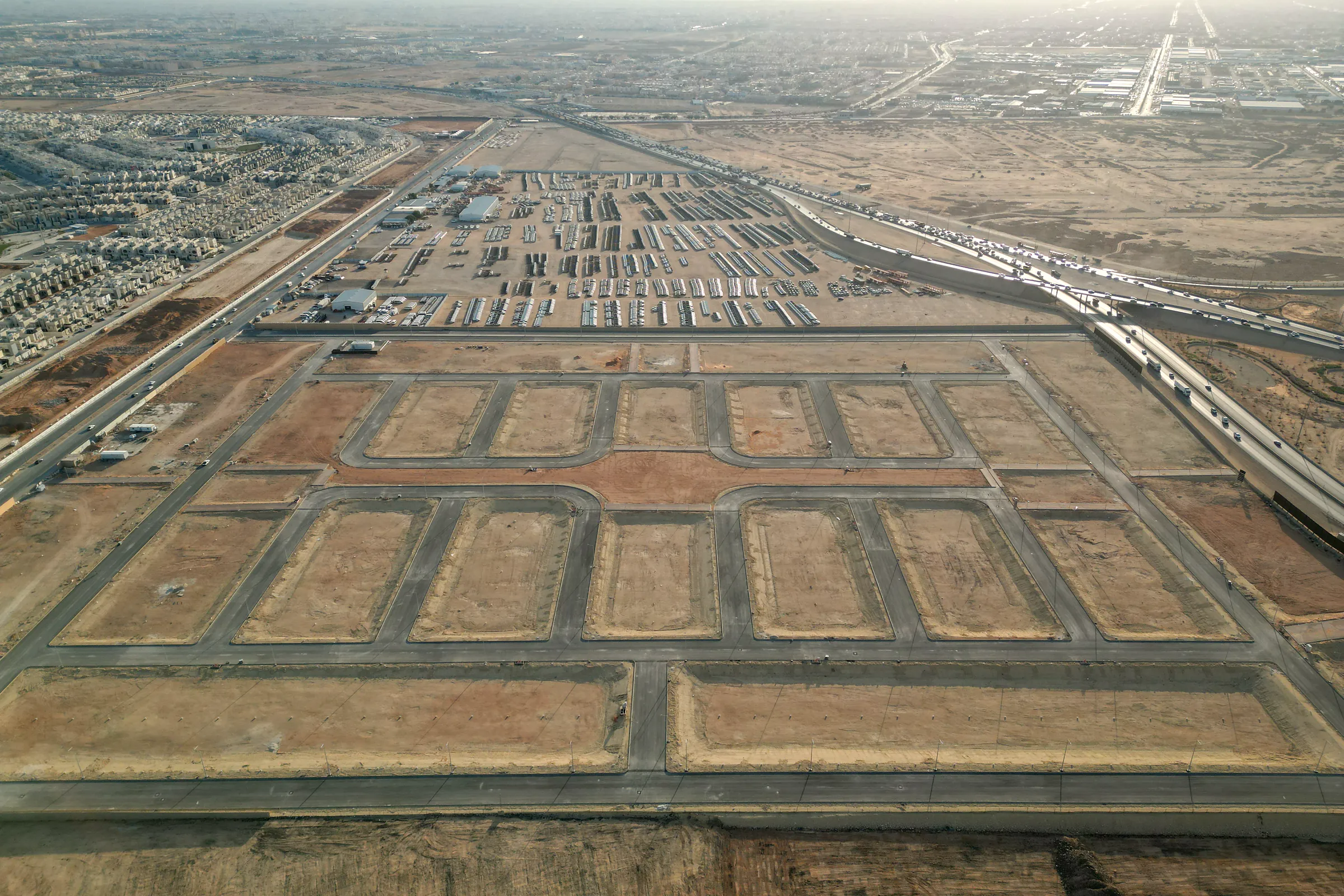 Looking across the scheme's blocks and paved streets toward the neighbouring sites