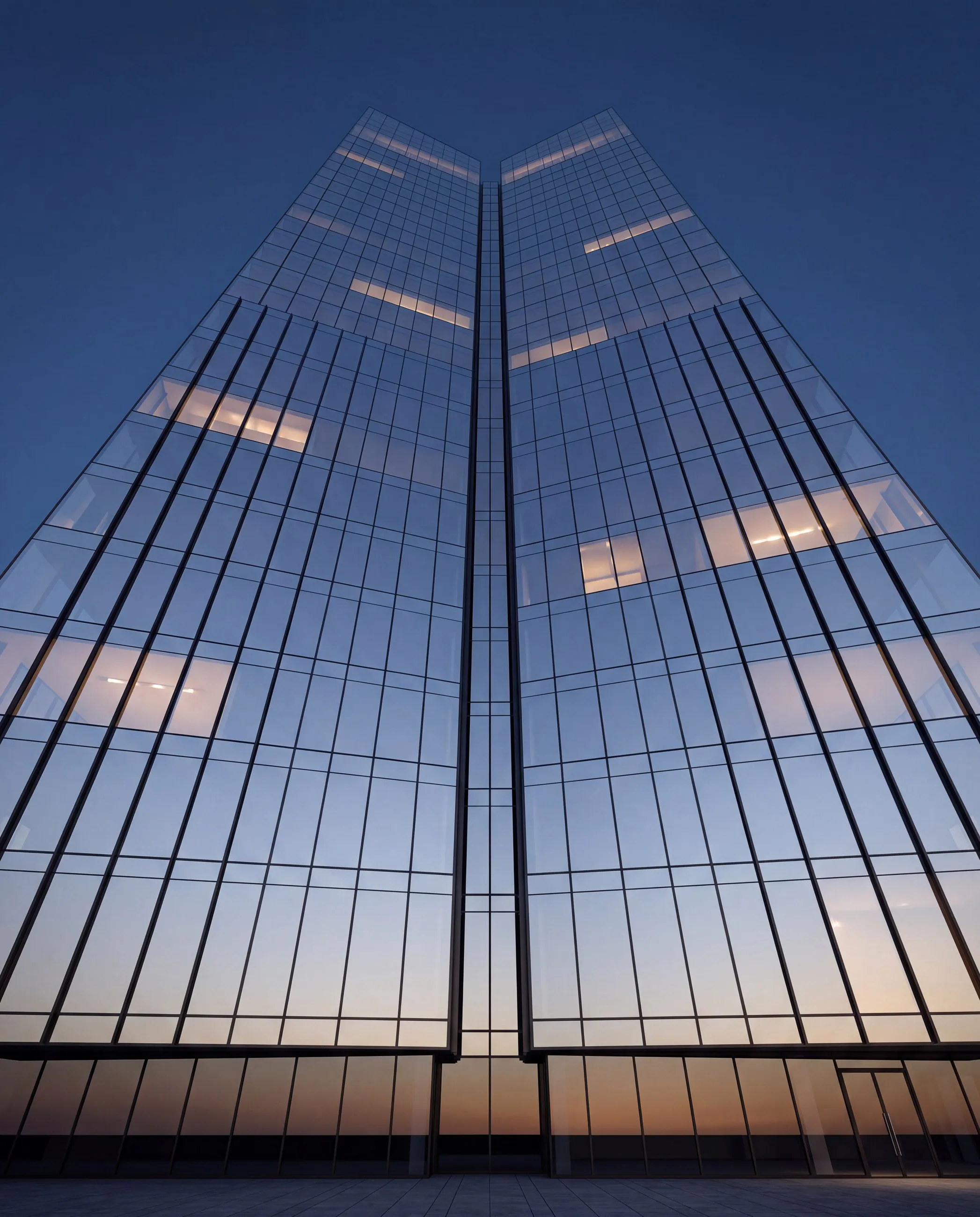 The glass tower seen from below against a deep blue sky.